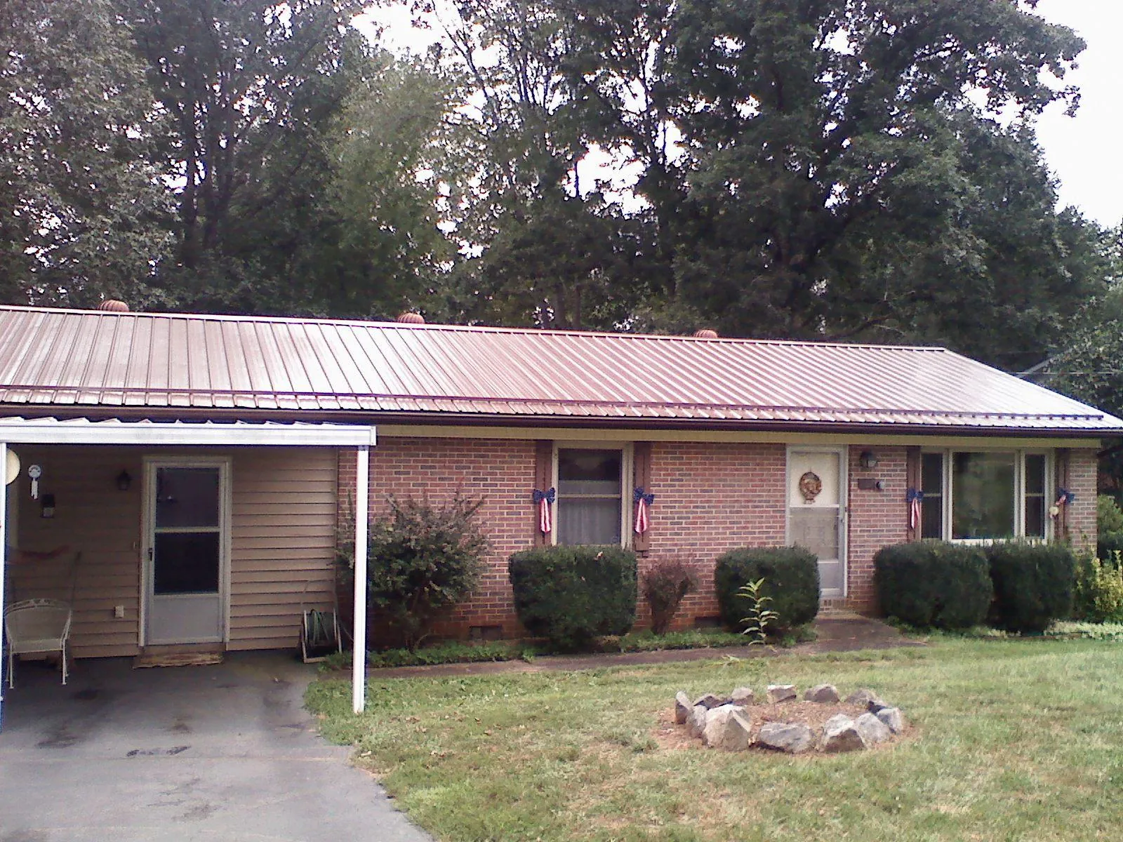 Bronze metal roof and carport on a brick ranch home — Roof Repair work by our crew in Reddick