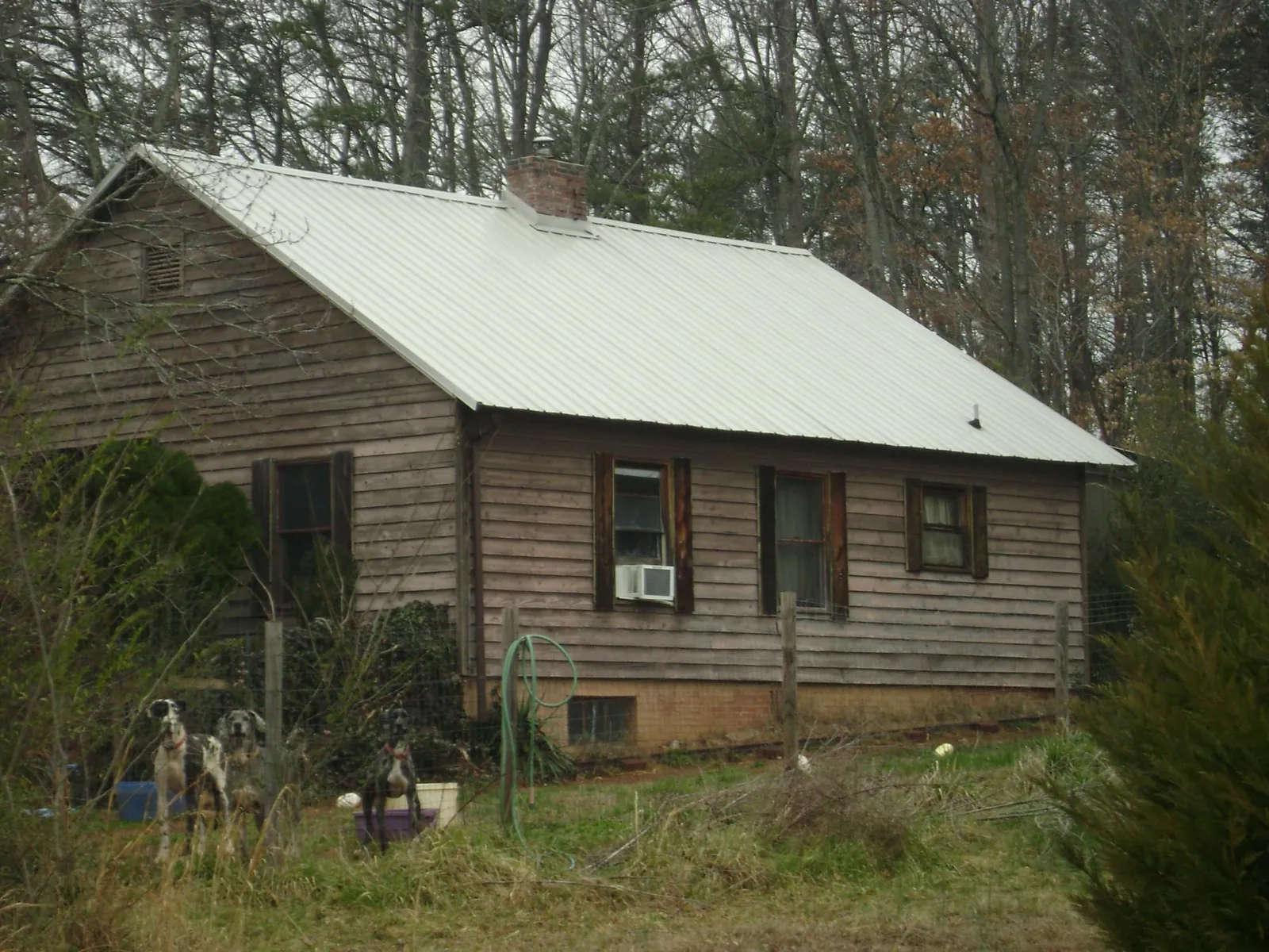 White metal roof on an old wood sided farmhouse, from a Metal Roof Installation job in Reddick